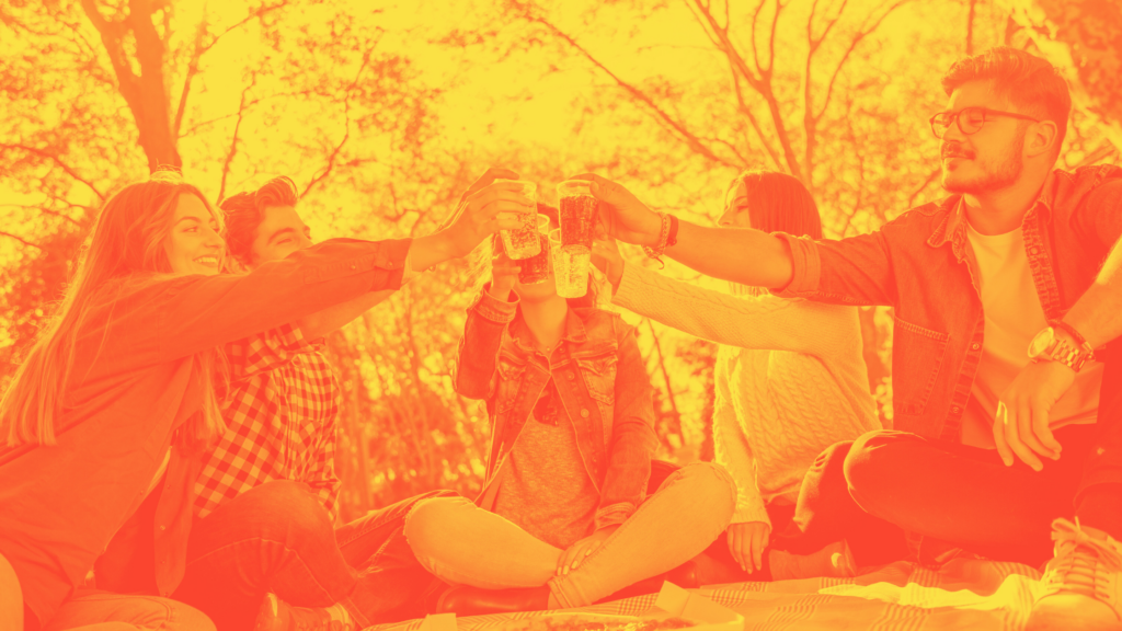 friends at a picnic cheersing their cups of gazpacho