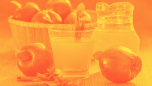 Cup of apple cider vinegar surrounded by apples and basket of apples. In yellow red duotone effect